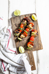 Grill skewers with grilled chicken, tomato, bell pepper and zucchini on chopping board - SBDF03710