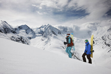 Junge Leute klettern mit ihrer Skiausrüstung auf den Gipfel eines Berges - ISF18538