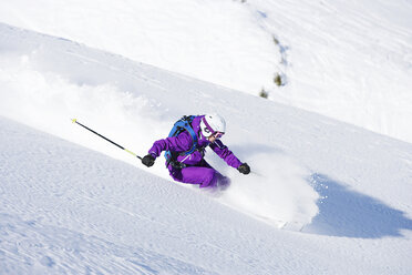 Weibliche Skifahrerin bei Geschwindigkeit bergab - ISF18547