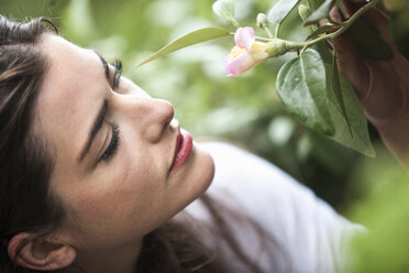 Close up portrait of young woman holding blossom - ISF18558