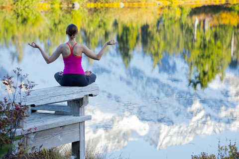 Meditierende Frau am See, Bellingham, Washington, USA, lizenzfreies Stockfoto