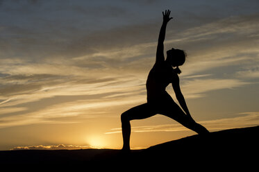 Young woman doing yoga in sunlight, Moab, Utah, USA stock photo