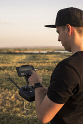 Man holding remote control for a drone in a field - ACPF00147