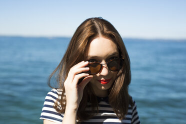 Italy, Lake Garda, portrait of smiling young woman with sunglasses - GIOF04049