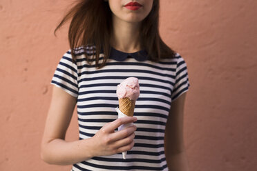 Young woman holding ice cream cone with one scoop, partial view - GIOF04061