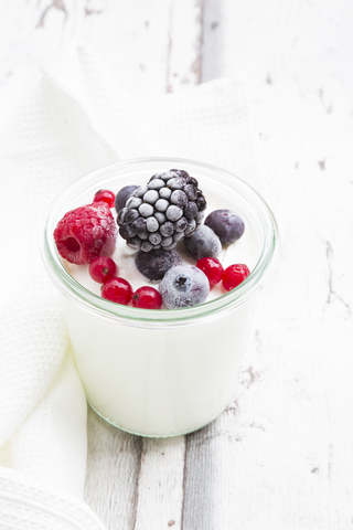 Ein Glas griechischer Joghurt mit gefrorenen Beeren, lizenzfreies Stockfoto