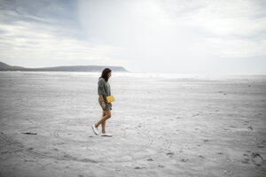 South Africa, Western Cape, Noordhoek, woman walking on the beach - DAWF00674