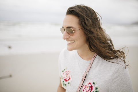 Porträt einer glücklichen Frau am Strand, lizenzfreies Stockfoto