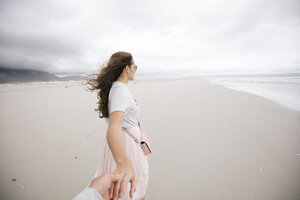South Africa, Western Cape, Hermanus, woman holding hand on the beach - DAWF00692