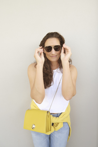 Portrait of smiling brunette woman wearing sunglasses stock photo