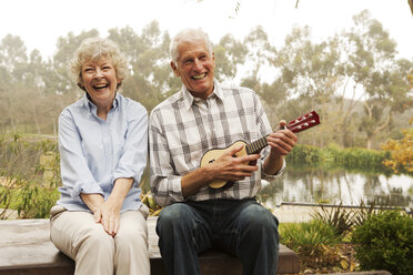 Ehemann spielt Ukulele mit Frau am See - ISF18617