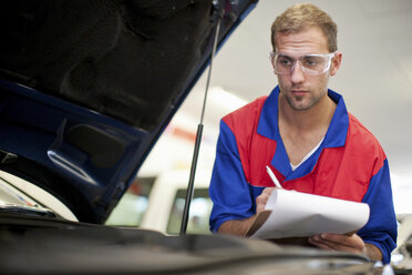 Automechaniker bei der Arbeit in der Servicebucht - ISF18636