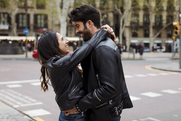 Spain, Barcelona, happy young couple hugging on the street - MAUF01540