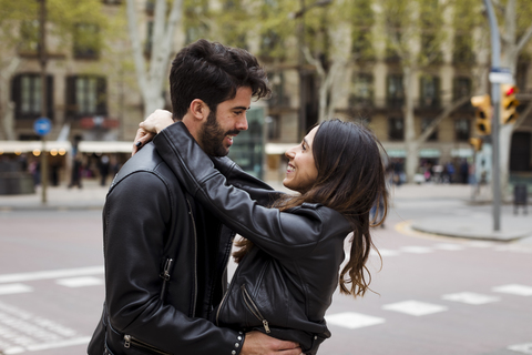 Spanien, Barcelona, glückliches junges Paar, das sich auf der Straße umarmt, lizenzfreies Stockfoto
