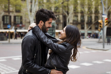 Spain, Barcelona, happy young couple hugging on the street - MAUF01541