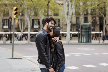 Spanien, Barcelona, glückliches junges Paar, das sich auf der Straße umarmt - MAUF01542