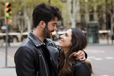 Spanien, Barcelona, glückliches junges Paar, das sich auf der Straße umarmt - MAUF01543