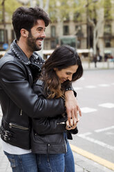 Spanien, Barcelona, glückliches junges Paar, das sich auf der Straße umarmt - MAUF01544