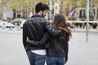 Spanien, Barcelona, junges Paar, das sich umarmt und in der Stadt spazieren geht - MAUF01545