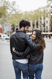 Spanien, Barcelona, junges Paar, das sich umarmt und in der Stadt spazieren geht - MAUF01546