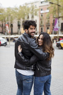 Spanien, Barcelona, junges Paar, das sich umarmt und in der Stadt spazieren geht - MAUF01548