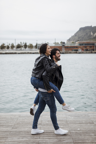 Spanien, Barcelona, glückliches junges Paar, das sich an der Küste amüsiert, lizenzfreies Stockfoto