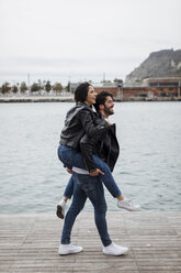 Spanien, Barcelona, glückliches junges Paar, das sich an der Küste amüsiert - MAUF01551