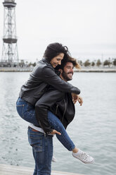 Spanien, Barcelona, glückliches junges Paar, das sich an der Küste amüsiert - MAUF01552