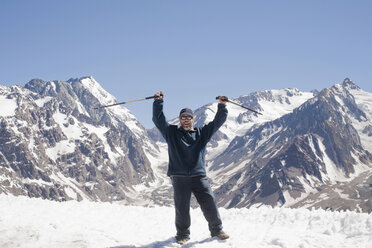 Hiker cheering on snowy mountaintop - ISF18679