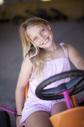 Girl riding go-kart in garage - ISF18682