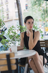 Young businesswoman sitting in coffee shop, taking a break, drinking tea - KKAF01247