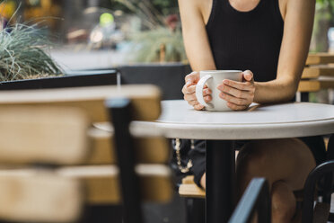 Junge Geschäftsfrau sitzt in einem Café, macht eine Pause und trinkt Tee - KKAF01255