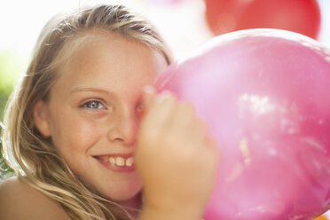 Smiling girl holding balloon at party - ISF18759