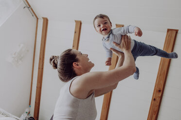 Mother playing with her baby son at home - JLOF00082