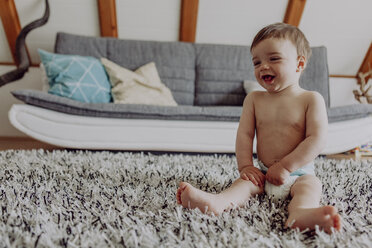 Glückliches Baby spielt auf dem Teppich - JLOF00121