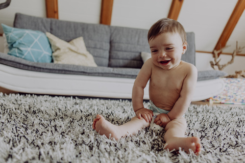 Glückliches Baby spielt auf dem Teppich, lizenzfreies Stockfoto