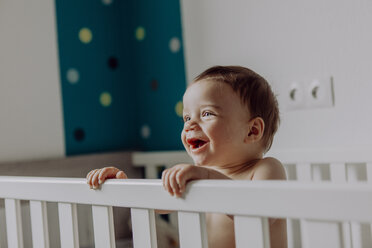 Lachender kleiner Junge in seinem Kinderbettchen - JLOF00138