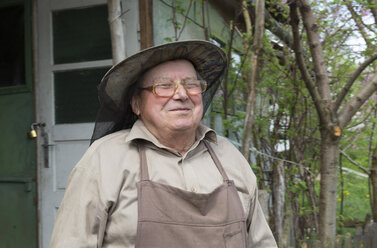 Rumania, Ciresoaia, Portrait of smiling beekeeper with beekeper's hood - MABF00487