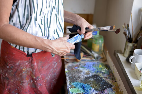 Female painter in her atelier, paint tube and paintbrushes - BFRF01882