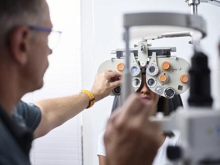Optometrist untersucht das Auge einer jungen Frau - CVF01032