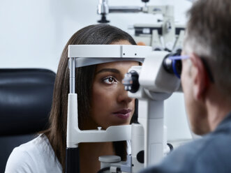 Optometrist examining young woman's eye - CVF01038