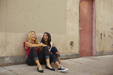 Frauen sitzen lachend auf dem Boden - ISF18908