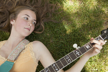 Teenager-Mädchen spielt Banjo im Gras, Draufsicht - ISF18992