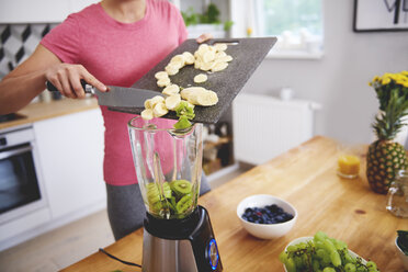 Young woman preparing smoothie in the kitchen, partial view - ABIF00778