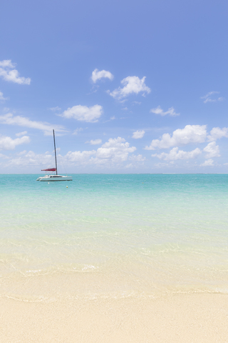 Mauritius, Grand Port District, Pointe d'Esny, Segelboot in türkisfarbenem Wasser, blauer Himmel und Wolken, lizenzfreies Stockfoto