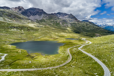 Schweiz, Kanton Graubünden, Luftaufnahme von Seen und Bahnstrecke der Berninabahn und Berninapass, lizenzfreies Stockfoto