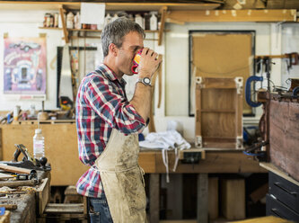 An antique furniture restorer in his workshop having a coffee break. - MINF03046