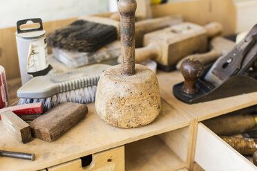 Werkstatt für die Restaurierung von antiken Möbeln: Eine Werkbank mit einem Holzhobel, einem großen Hammer, Pinseln und Handwerkzeugen. - MINF03050