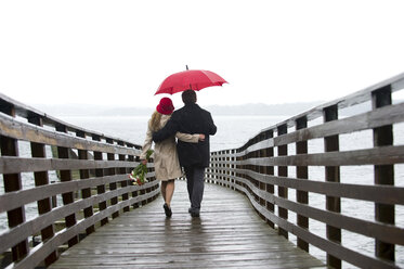 Paar geht auf Holzsteg im Regen - ISF18995