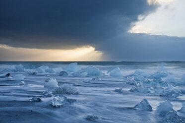 Icebergs on beach with stormy sky, Jokulsarlon, Iceland - ISF19015